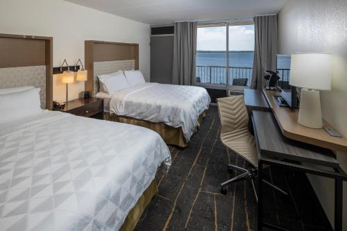a hotel room with two beds and a desk at Holiday Inn Detroit Lakes by IHG in Detroit Lakes