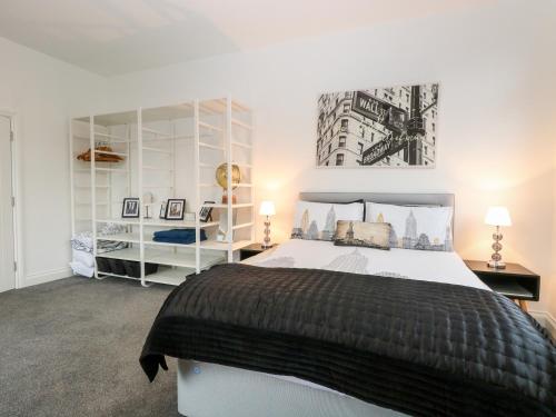 een slaapkamer met een groot bed en witte planken bij Apartment 7 in Lowestoft