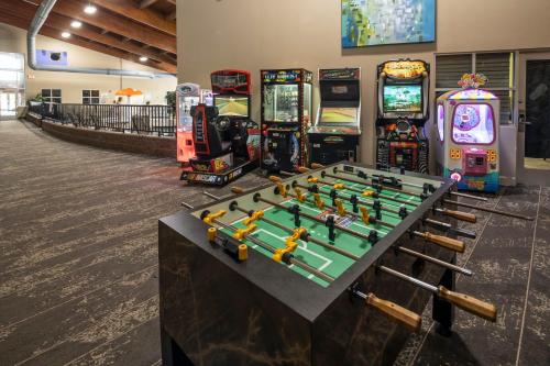 a group of arcade games in a room with a table at Holiday Inn Detroit Lakes, an IHG Hotel in Detroit Lakes