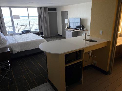 a hotel room with a bed and a kitchen with a sink at Holiday Inn Detroit Lakes by IHG in Detroit Lakes