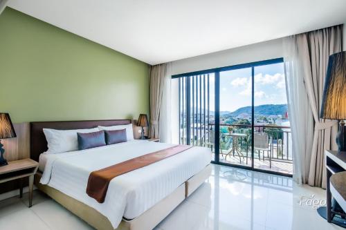 a bedroom with a large bed and a large window at The Pago Design Hotel Phuket-SHA Plus in Phuket Town