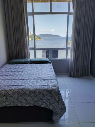 a bedroom with a bed with a view of the ocean at Mirante de São Vicente in São Vicente