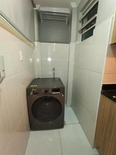a bathroom with a washing machine in a room at Mirante de São Vicente in São Vicente