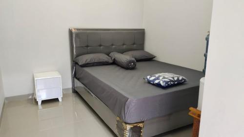 uma cama com duas almofadas num quarto em JM HOMESTAY em Pangandaran
