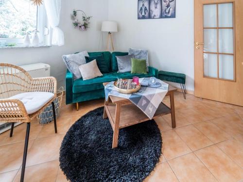 a living room with a green couch and a table at Family Stay in Suhl Forest in Suhl