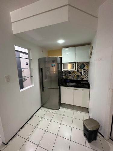 eine Küche mit einem Kühlschrank aus Edelstahl und einer Mikrowelle in der Unterkunft Flat Biarritz - Ao lado da Litoranea - Ferreira Hospedagens in São Luís