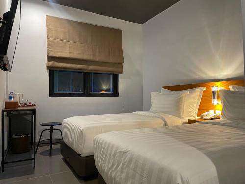 ラゴイにあるd'primahotel Lagoi Bintanのベッド2台と窓が備わるホテルルームです。