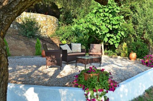 a patio with a couch and chairs and flowers at Philippos 1 in Diaporos
