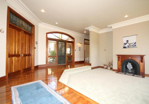 an empty living room with a fireplace and wooden floors at Relaxin in Dural