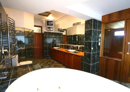 baño grande con 2 lavabos y espejo grande en Relaxin, en Dural
