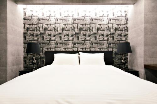 a bedroom with a large white bed with two lamps at Regalo芝浦 501 in Tokyo