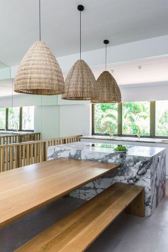 a kitchen with a wooden table and a stone bench at Little Cove Treetops Little Cove Magic in Noosa Heads