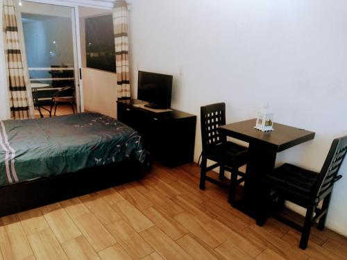 a bedroom with a bed and a desk and a table at Exelentes departamentos y lofts en el centro de la ciudad de Teziutlán in Teziutlán