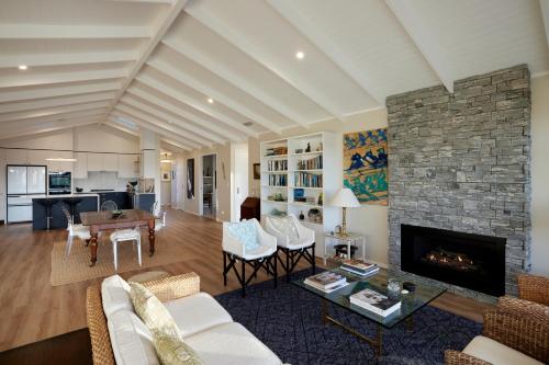 a living room with a fireplace and a stone wall at Omokoroa Golfers Retreat - B&B in Omokoroa