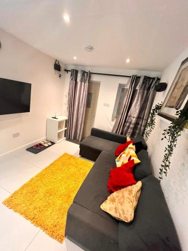 a living room with a couch and a tv at Cerrkuss Stays in London