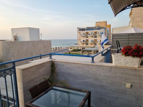 a balcony with a swimming pool and a view of the beach at Pearl island suite in Ashkelon