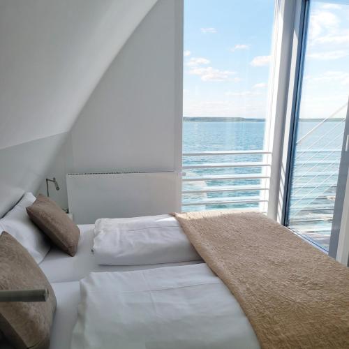 a bedroom with a bed in front of a large window at Ferienhaus Water in Geierswalde