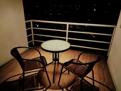 a table and two chairs on a balcony at night at Exelentes departamentos y lofts en el centro de la ciudad de Teziutlán in Teziutlán