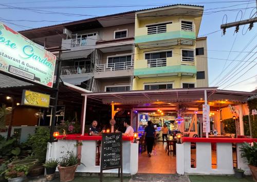 a restaurant in front of a tall building at Rose Garden Guest House Soi 88 Hua Hin in Hua Hin