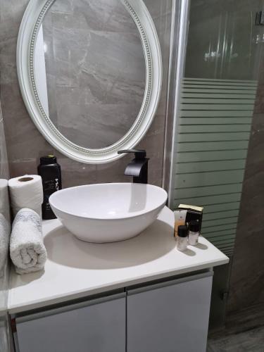 a bathroom with a white sink and a mirror at Pearl island suite in Ashkelon