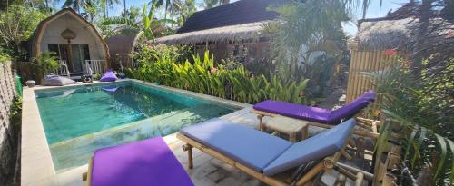 龍目島的住宿－Purple Beach - Maïthélia - Gili Air，一个带椅子的游泳池以及一座房子
