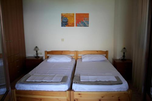 2 aparte bedden in een slaapkamer met een foto aan de muur bij Miranta in Nikiti