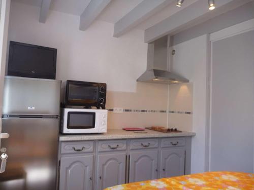 La cuisine est équipée d'un four micro-ondes et d'un réfrigérateur. dans l'établissement Maison rénovée proche plage, quartier calme, parking privé, animaux acceptés - FR-1-387-108, à Marseillan