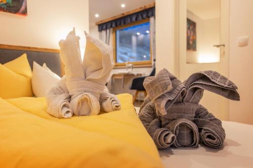 two stuffed animals are sitting on a bed at Art-Apartments Kartnaller superior in Neustift im Stubaital