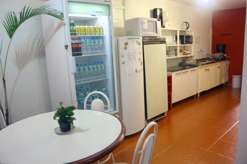 a kitchen with a table and a refrigerator at Pousada e Hostel São Paulo Econômica in São Paulo