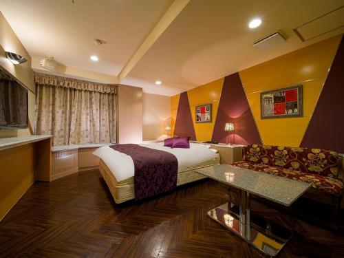 una camera d'albergo con letto e divano di HOTEL U's Kouroen - Vacation STAY 11230v a Nishinomiya