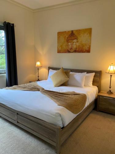 una camera da letto con un grande letto con lenzuola e cuscini bianchi di Emerald Creek Cottages a Emerald