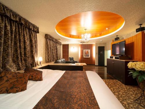 a hotel room with a large bed and a living room at HOTEL U's Kouroen - Vacation STAY 11259v in Nishinomiya