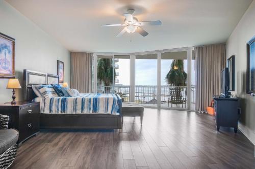 a bedroom with a bed and a television and a balcony at Caribe Resort Unit C201 in Romar Beach