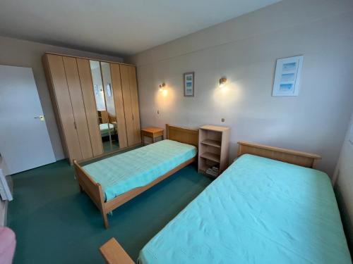 une petite chambre avec deux lits et un miroir dans l'établissement Appt plein centre , face mer avec parking, à Le Touquet-Paris-Plage