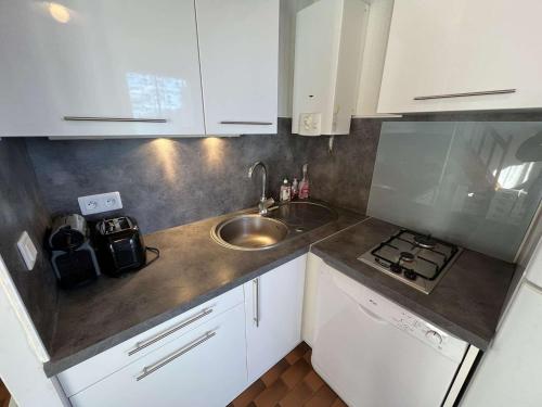 une petite cuisine avec un évier et une cuisinière dans l'établissement Appartement T2 Cabine, Rez-de-Jardin, Parking, Lave-Linge, Terrasse, Accès Plage à 30m - FR-1-702-16, au Cap d'Agde