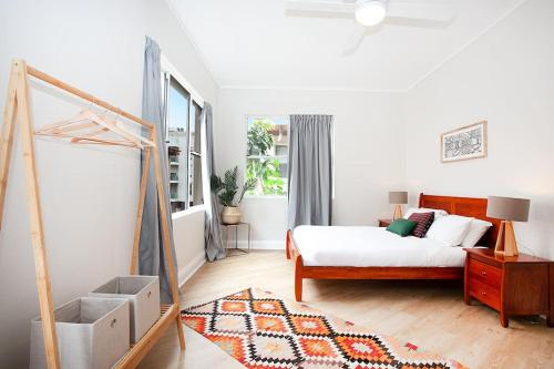 a white bedroom with a bed and a window at Large 4 Bed Beachside Haven 50m to Bondi Beach in Sydney