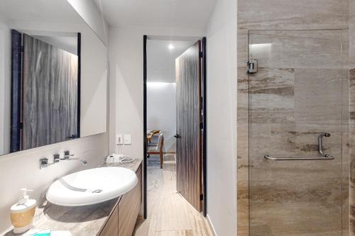 a bathroom with a sink and a glass shower at Kaab South Beach #309 in Playa del Carmen