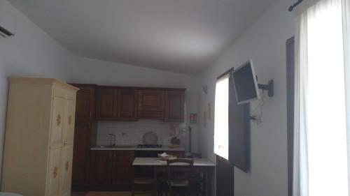 a kitchen with wooden cabinets and a table and a window at Vistamare in Orosei
