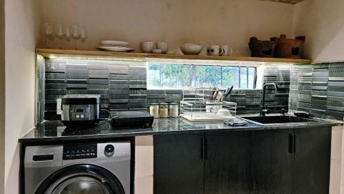 Il comprend une cuisine équipée d'un évier et d'un lave-linge. dans l'établissement Moon homestay Phu Yen, à Phú Lac