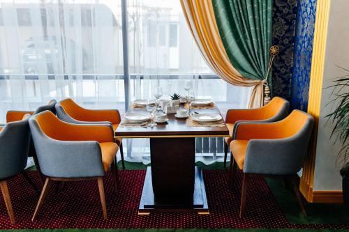 a dining room with a table and chairs and a window at Boutique Hotel Silk Way in Türkistan
