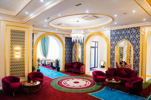 a lobby with red chairs and a red carpet at Boutique Hotel Silk Way in Türkistan