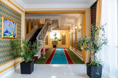 a hallway with a staircase and potted plants at Boutique Hotel Silk Way in Türkistan