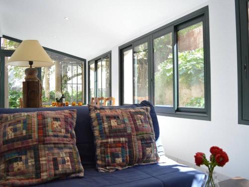 a blue couch with pillows in a room with windows at Appartement 4 pièces, 5 couchages, à deux pas de la plage, Banyuls-sur-Mer - FR-1-225C-577 in Banyuls-sur-Mer