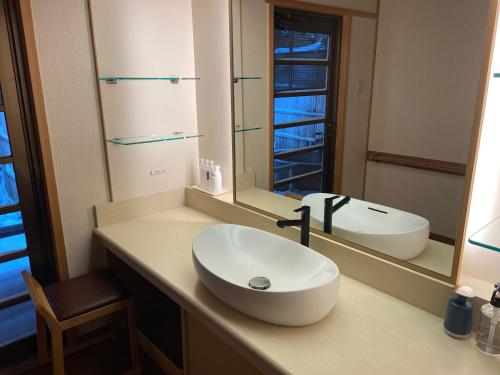La salle de bains est pourvue d'un lavabo et d'un miroir. dans l'établissement Shaga-no-Sato Yumeya, à Niigata