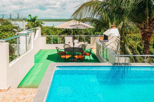 a swimming pool with a table and chairs next to a house at Hotel Tuparenda in Bacalar