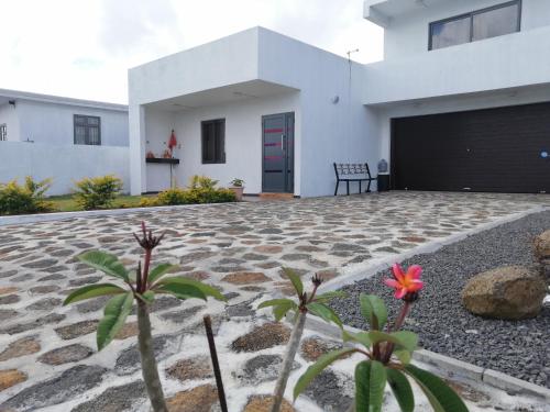 una casa blanca con una puerta roja y algunas plantas en A+villa, en Moka