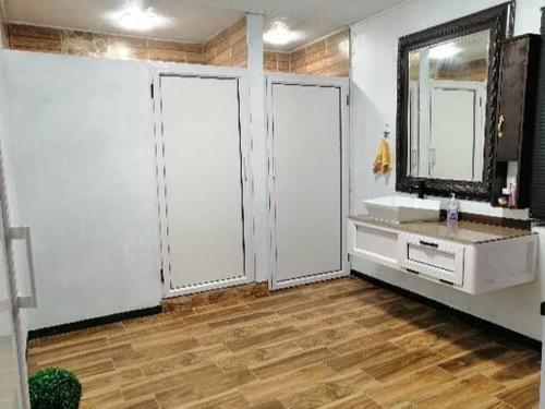 baño con 2 puertas, lavabo y espejo en A+villa, en Moka