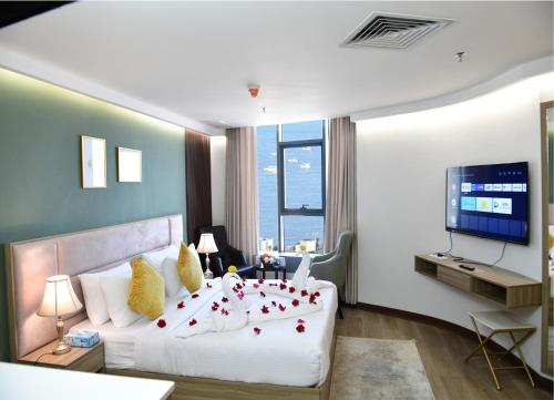 Al Salam Hotel في الكويت: غرفة نوم بسرير ابيض كبير وتلفزيون بشاشة مسطحة