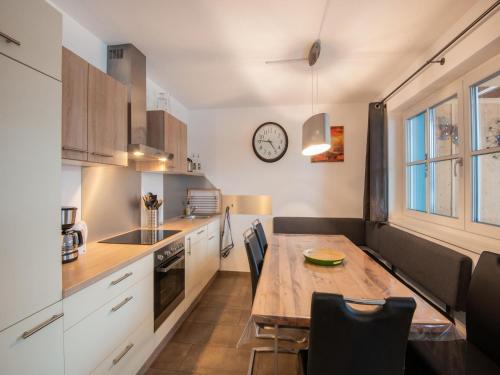 a kitchen with a table and a clock on the wall at Modern Apartment in Brixen im Thale near Ski Area in Feuring