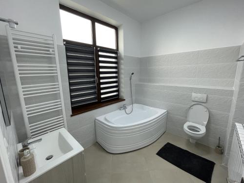 a white bathroom with a toilet and a sink at Racers' Home in Balş